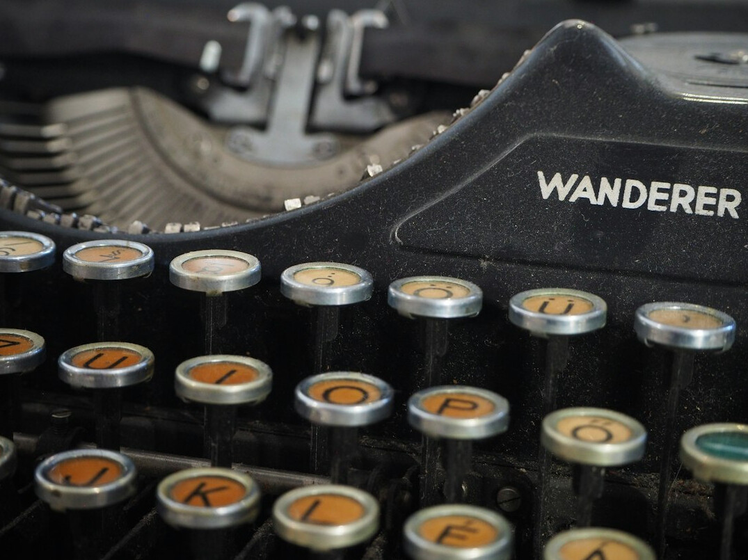 Vintage typewriter with a blank sheet of paper on a desk